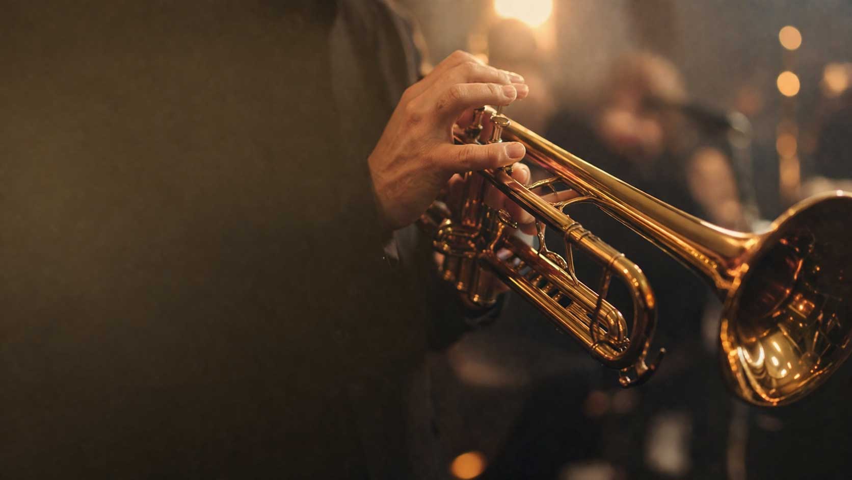 Professional trumpet player performing on a dimly lit club stage